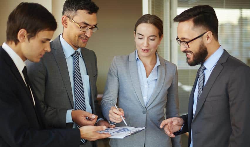 A team of business professionals reviewing financial documents together, illustrating EB5 investors consulting advisors about lawful investment immigration options amid policy changes.