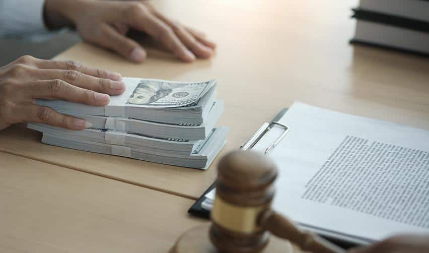 Stacks of U.S. dollar bills on a desk beside legal paperwork and a judge’s gavel, illustrating EB5 investment capital, source of funds review, and regulatory compliance.