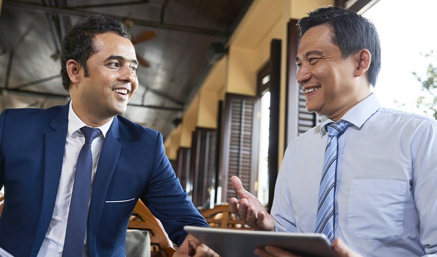Indian and East Asian business professionals meeting with a tablet, representing EB5 investors discussing visa backlogs, set-aside categories, and U.S. immigration strategy.